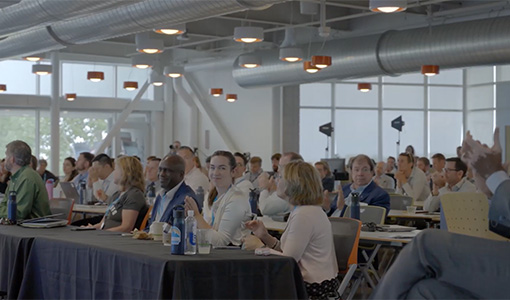 Continue reading about People clap while seated at conference tables.