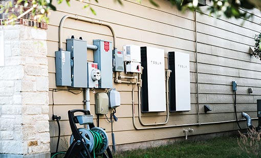 Photo of a Tesla power wall on the side of a house.