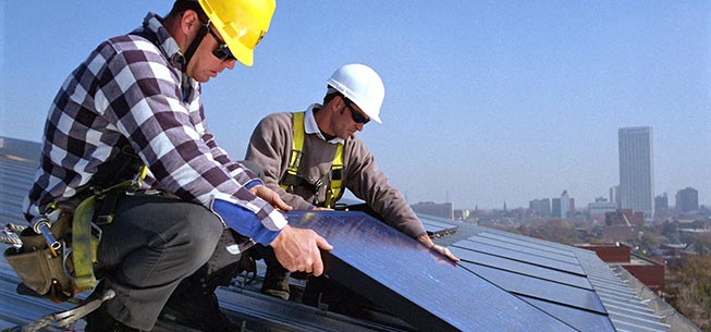 Two workers installing solar panels.