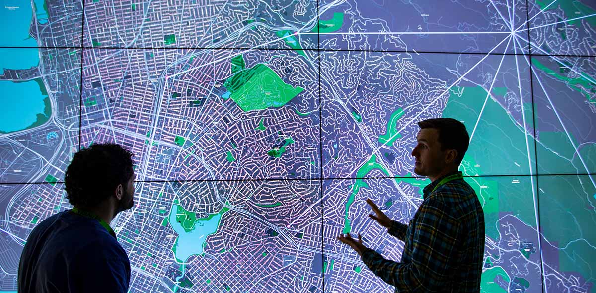 Scientists examine a projection of a grid in NREL's 2-D Visualization Laboratory
