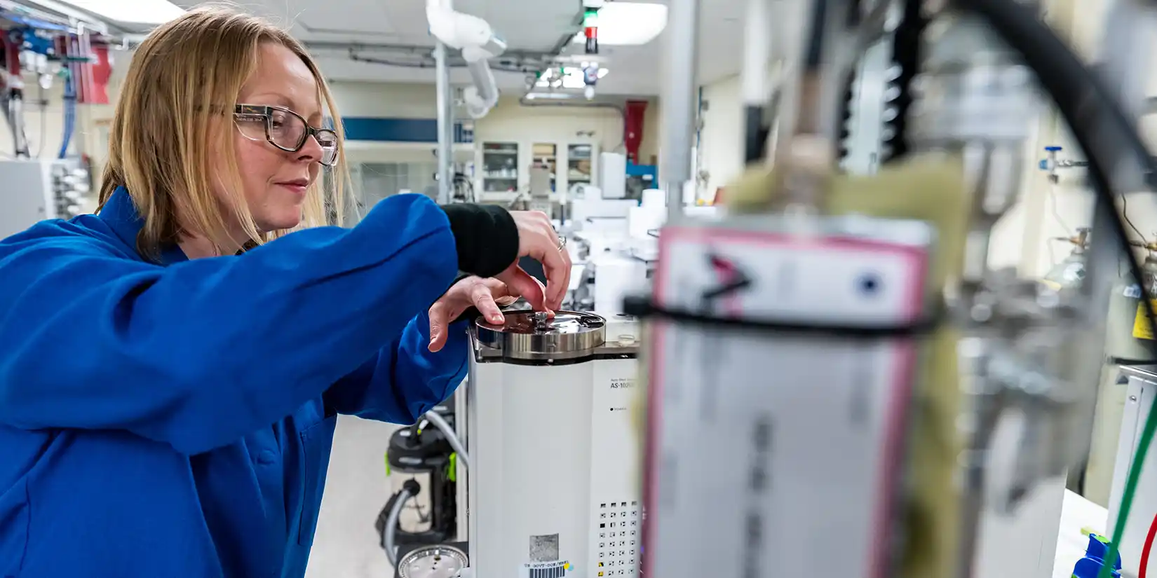 A researcher operates a high throughput pyrolysis molecular beam mass spectrometer.