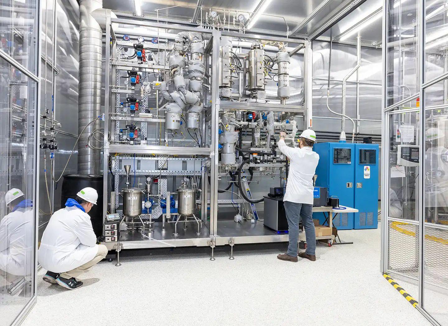 Two people wearing PPE working in a lab.