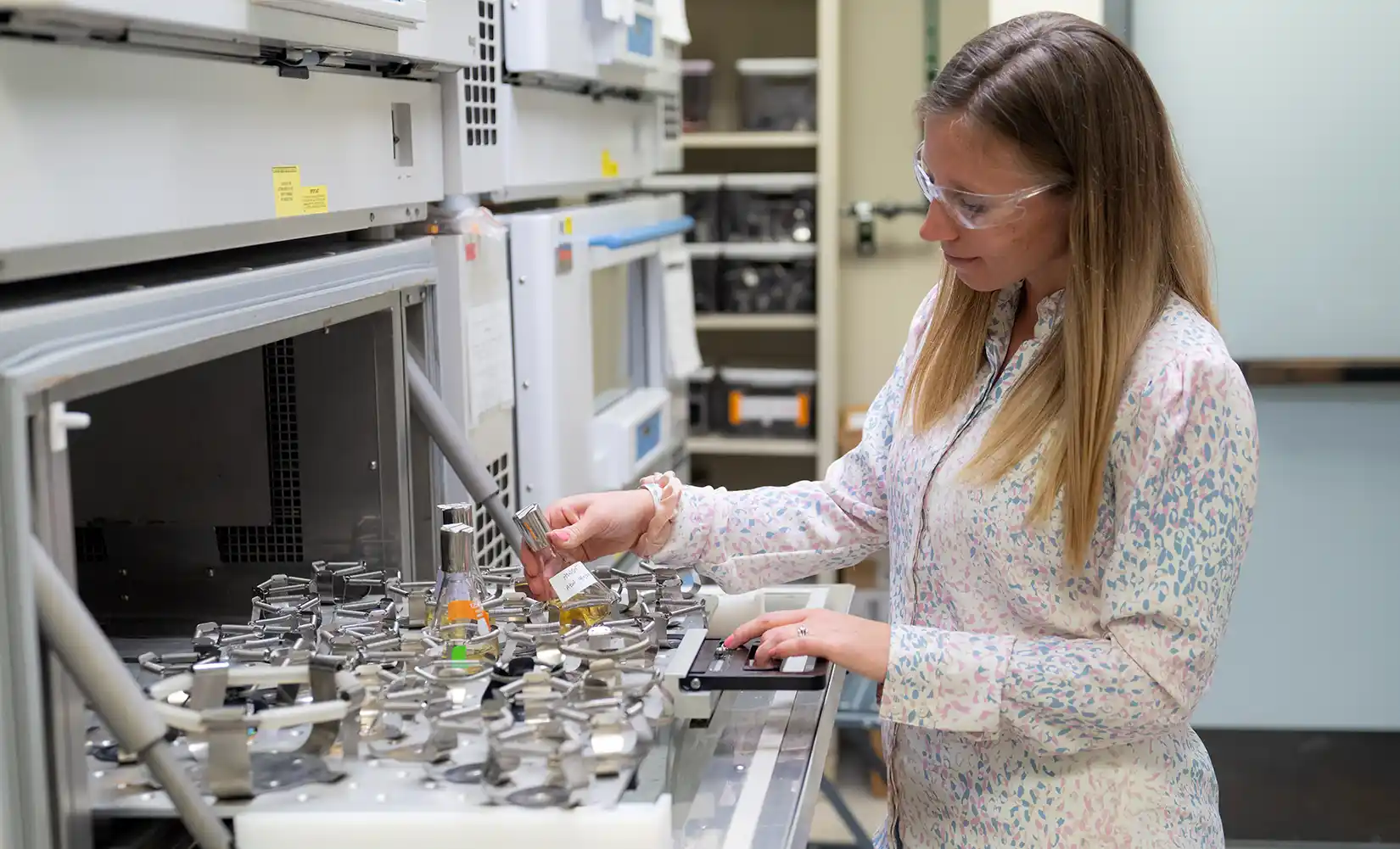 NREL researcher in lab prepares inoculated engineered bacteria in shake flasks.