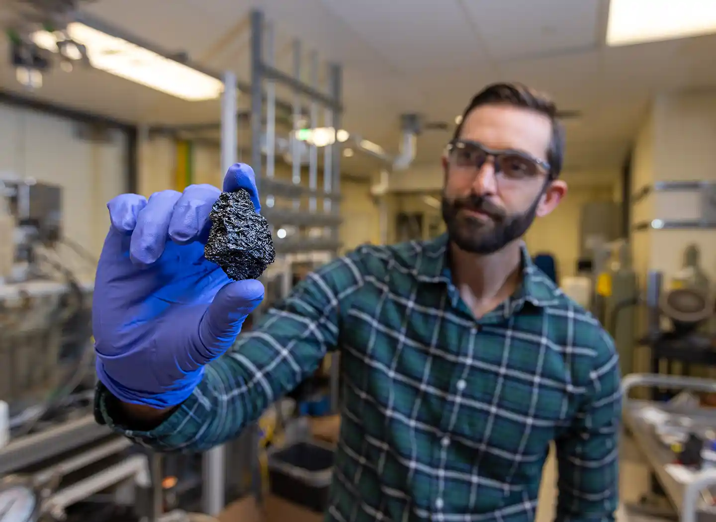 A researcher holds a chunk of bio-coke.