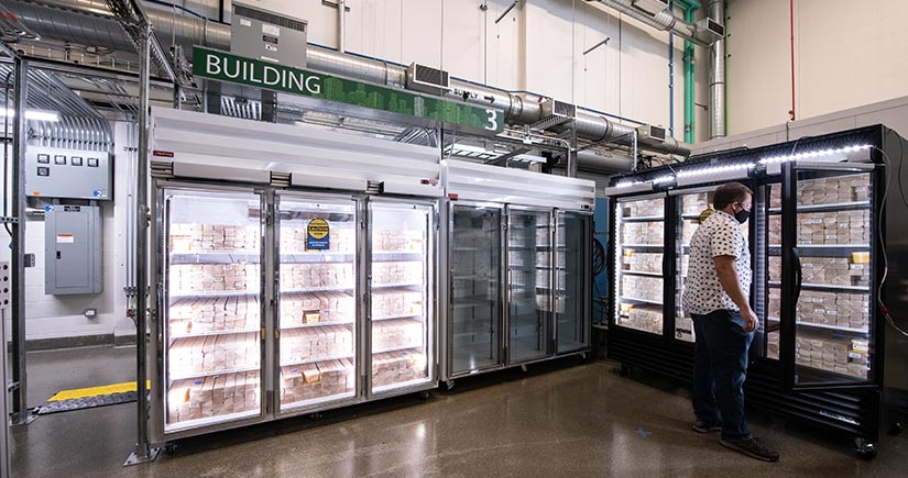 NLR Researcher stands in front of glass cases.