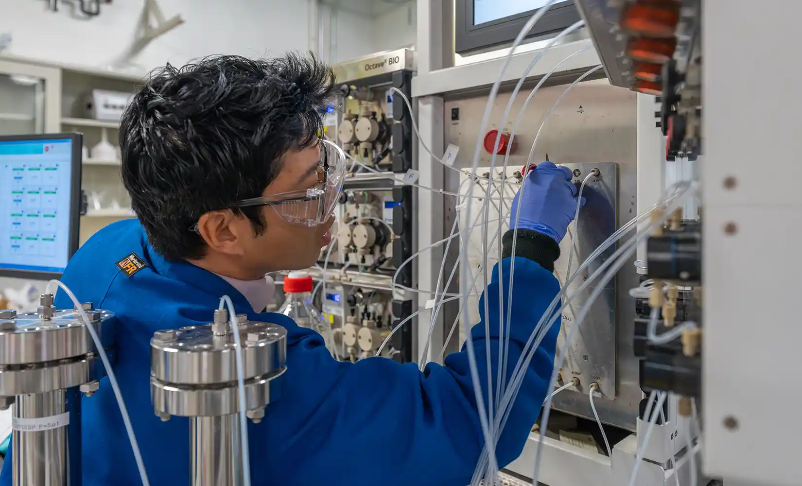 Researcher manipulating a multi-column chromatography system