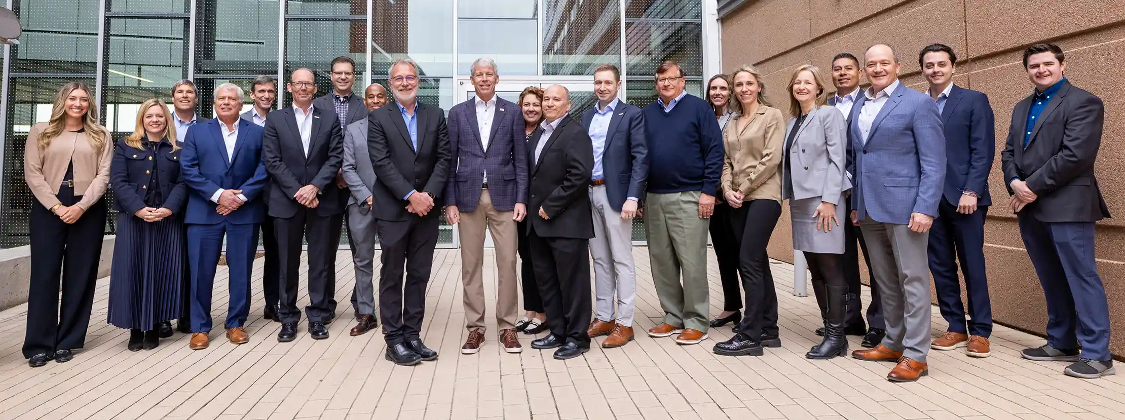 A group of 21 people pose for a photo outside NLR's Energy Systems Integration Facility.