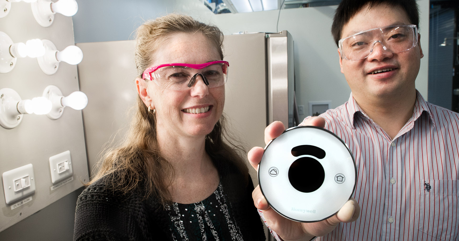 Photo of a pair of NLR researchers who received a record of invention for a home energy management system in a smart home laboratory.