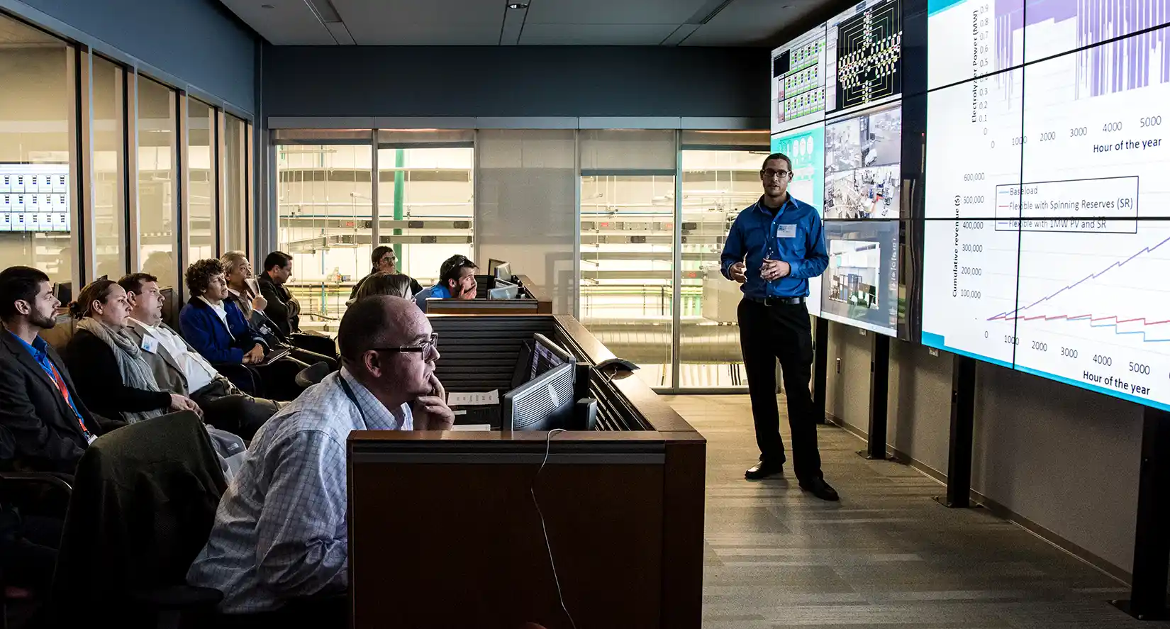 An NREL researcher presents on an electrolyzer grid integration demonstration in the control room of the Energy Systems Integration Facility.