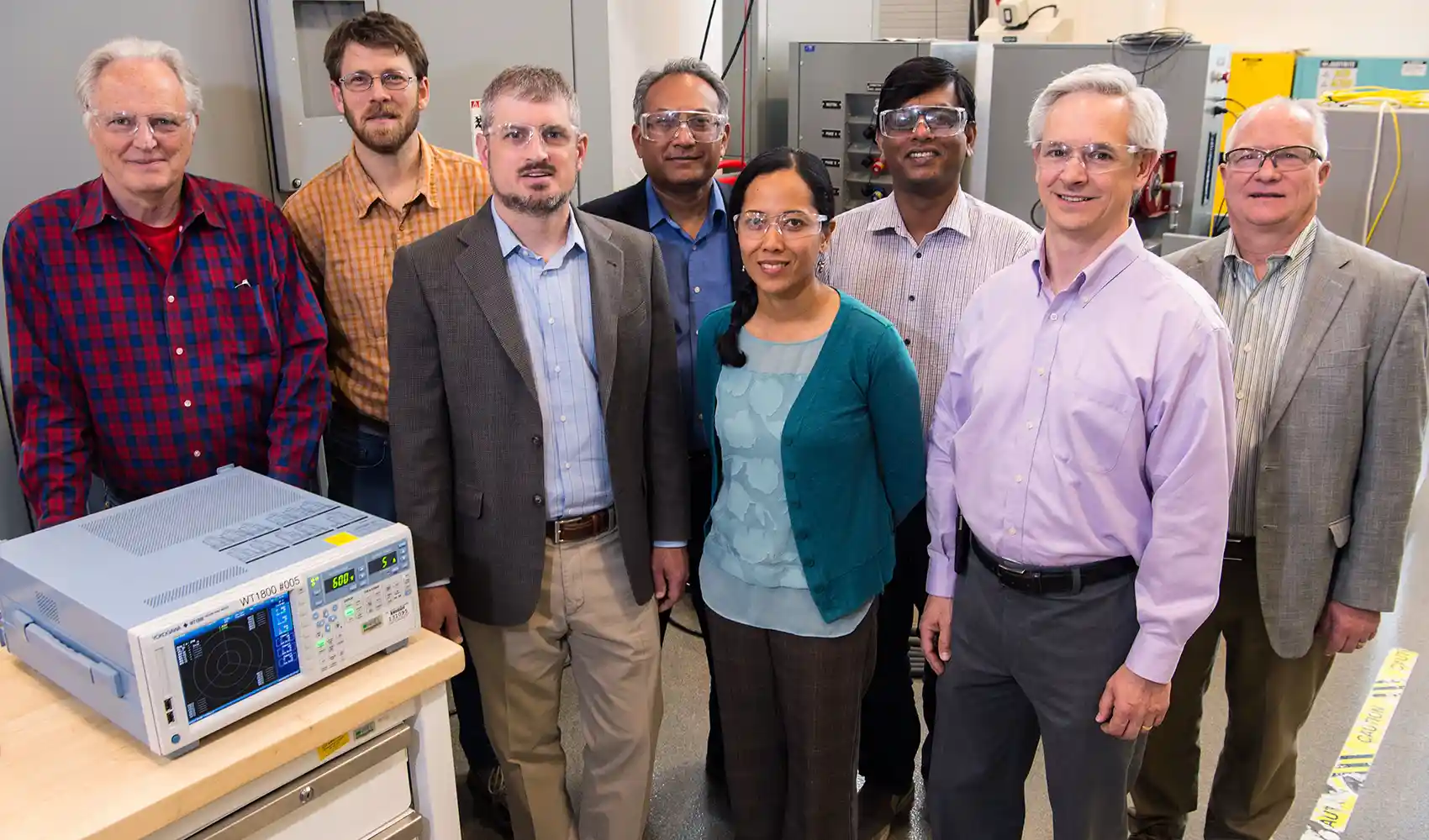 Group of researchers stand for photo inside lab.