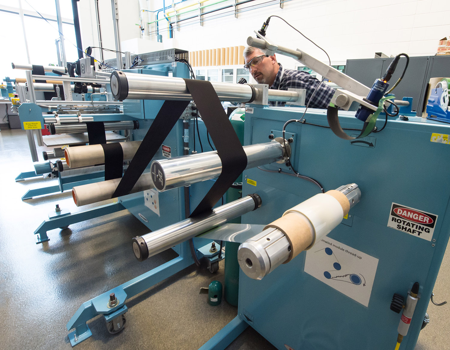 A researcher monitoring web-line equipment in the Manufacturing Laboratory