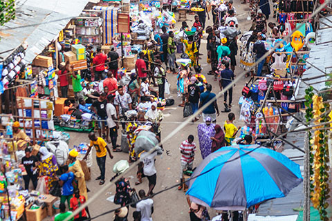 Photo of a busy street in Lagos, Nigeria, with lots of markets and people walking.