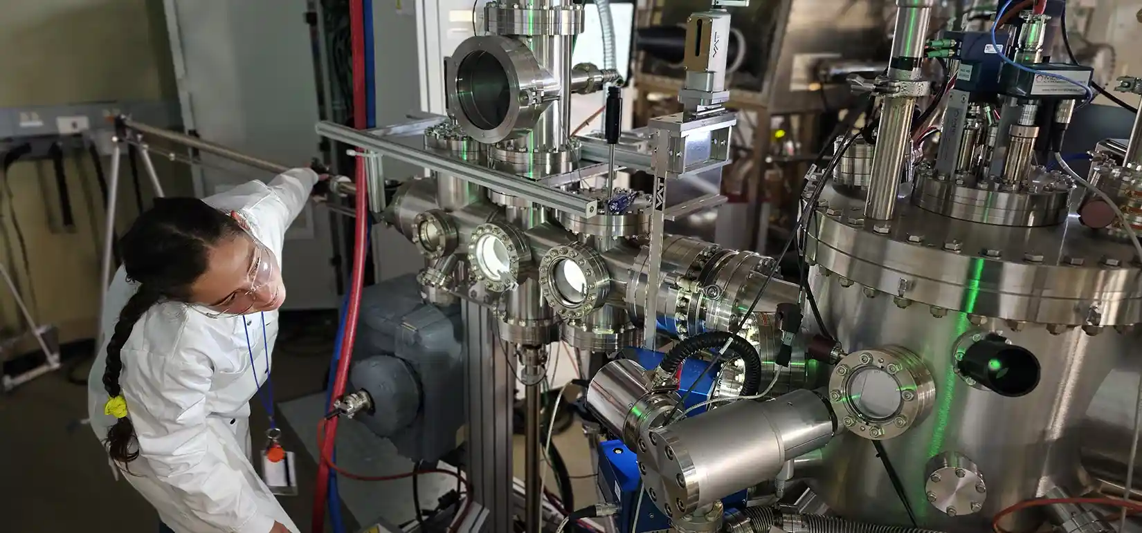 Researcher bends down over high-temperature device to inspect it inside lab