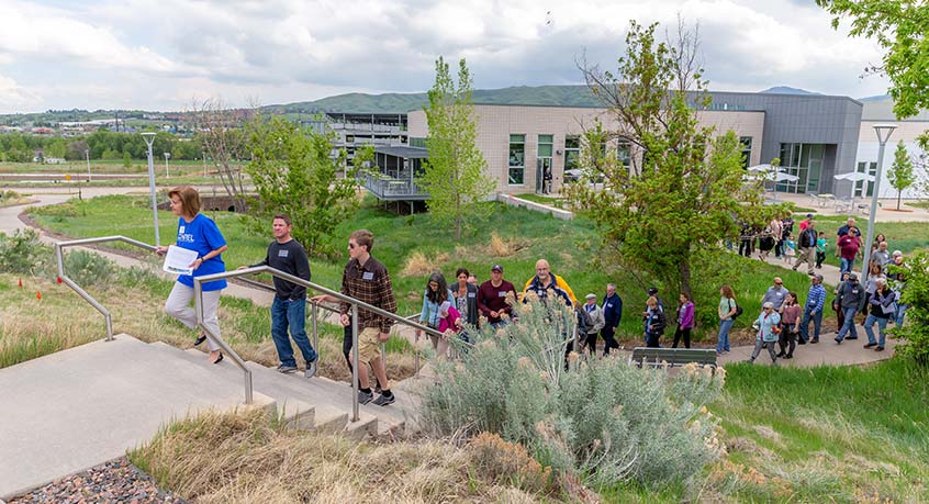 A woman leads a group of people up a set of stairs outdoors.