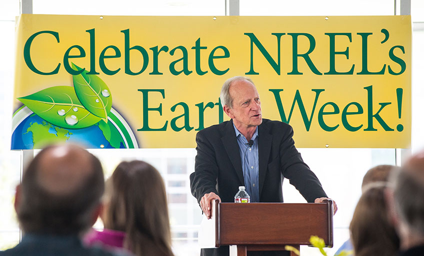 A man stands at a podium speaking in front of a crowd