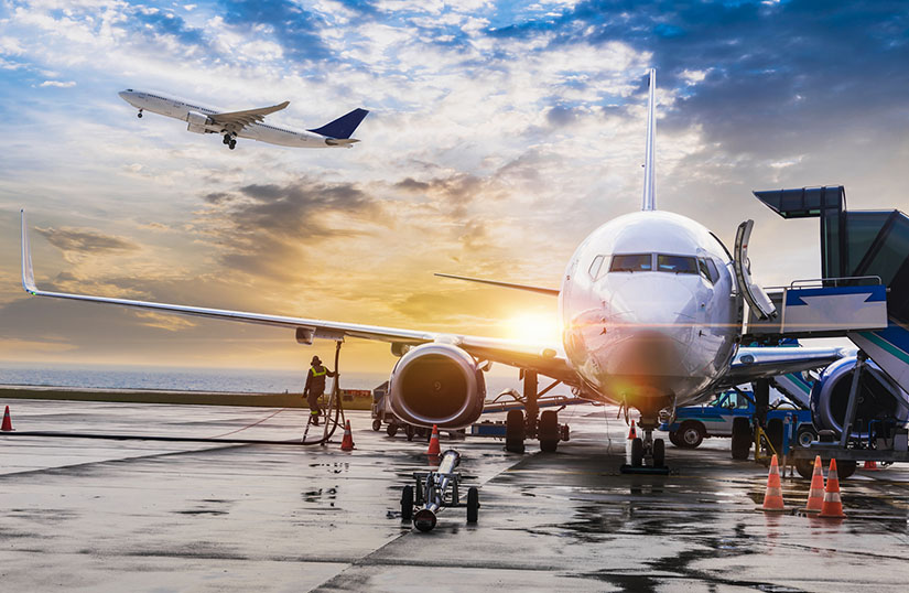 Photo of commercial airliners taking off and being refueled at an airport