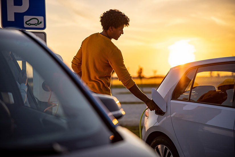 Photo of a man charging an electric vehicle