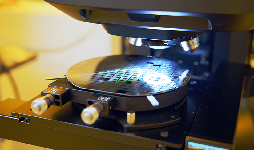A wafer of TPV cells sits under a microscope.