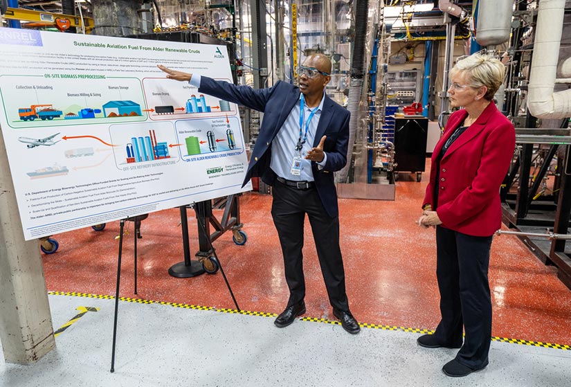 A researcher presents information on a poster to another person.