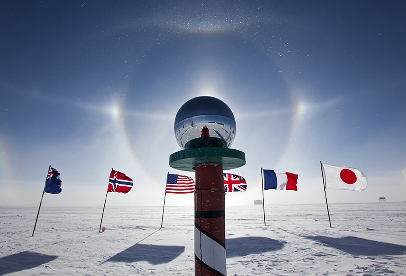 A glass orb in between a row of international flags.