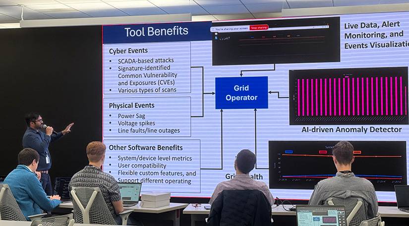 A man points to a screen while giving a presentation in front of an audience.