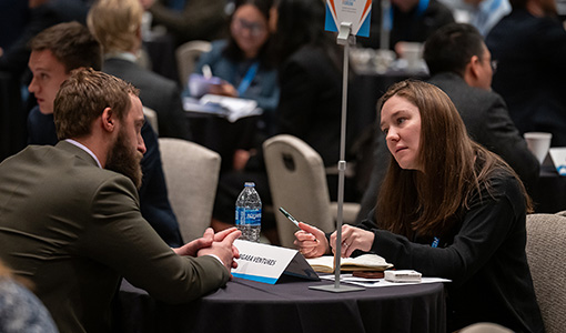 Continue reading about Twp people talking at a table.