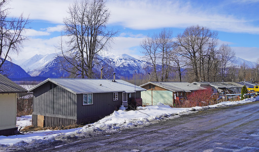 Continue reading about A row of homes with mountains in the background.