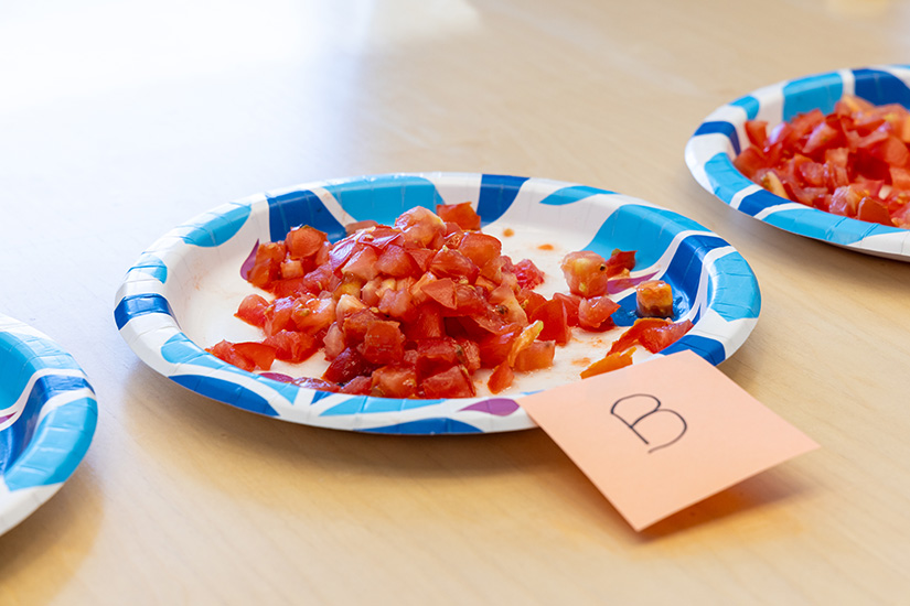 Chopped-up tomatoes sit on plates as part of a taste test.