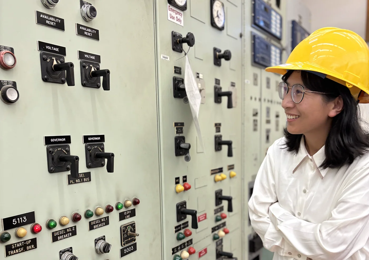 A person wearing a hard hat standing next to a panel wall.