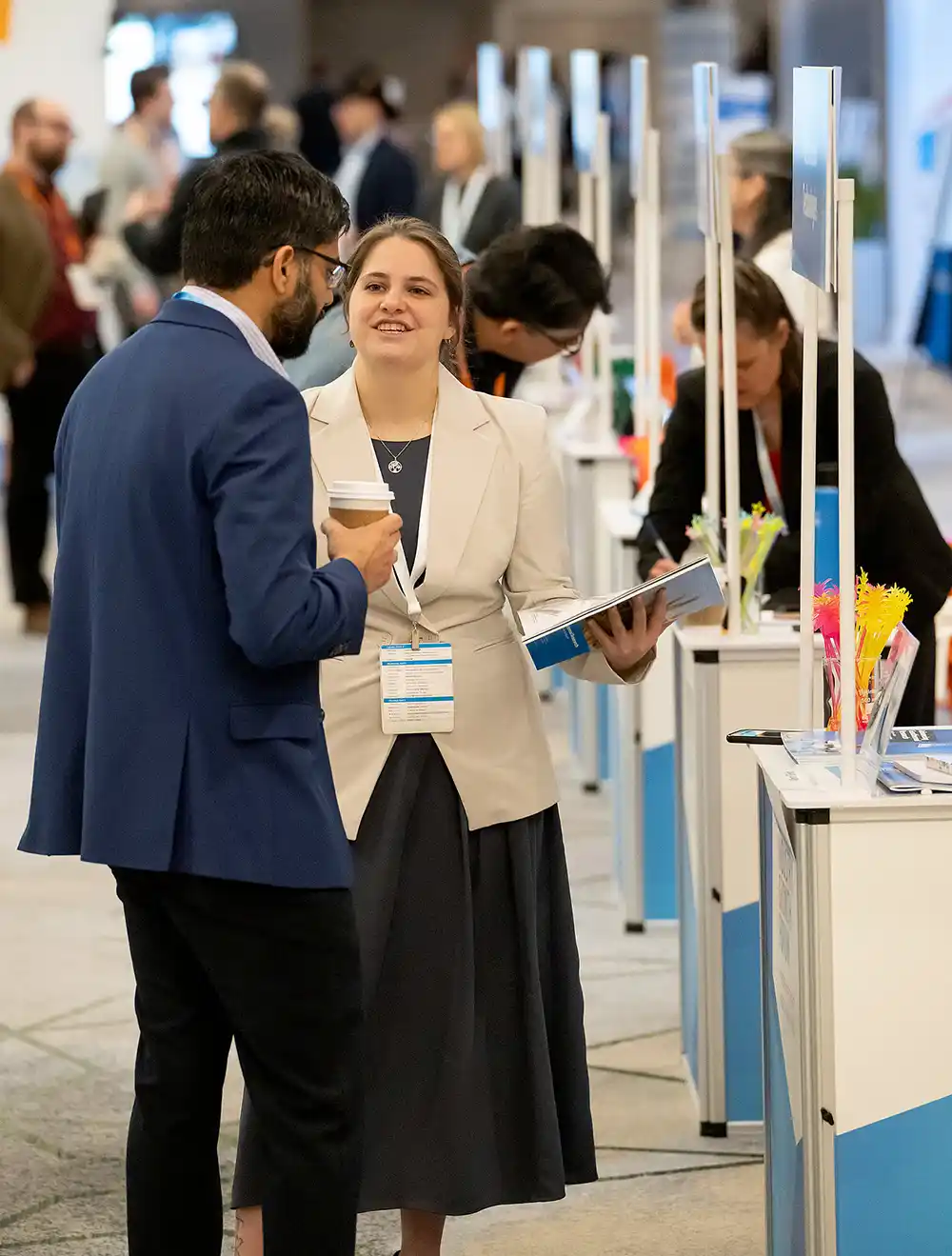 Woman and man in business attire talk across a “knowledge bar” table for one-on-one discussions with NLR staff.