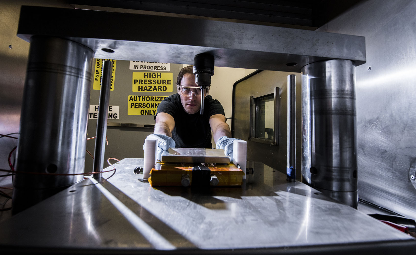 20260624-cradle-to-crisis-approach-improves-battery-safety-and-performance-054029 A person placing a battery into a metal chamber.