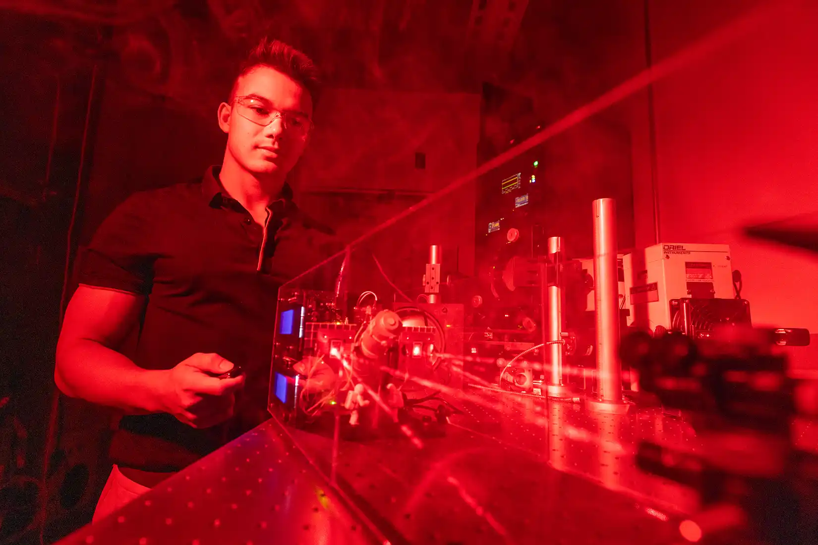 A graduate student works on laser equipment.