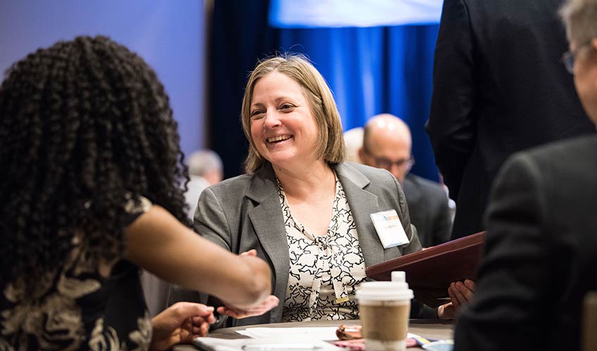 Photo of two women talking at a table. 
