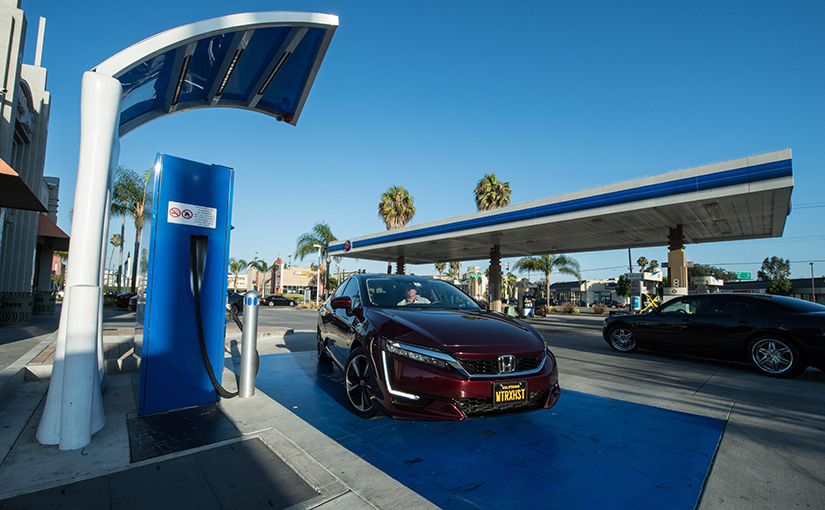 A car next to a hydrogen fueling pump.