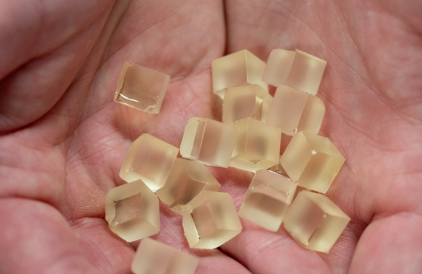 A hands holds cubes of the PECAN resin.