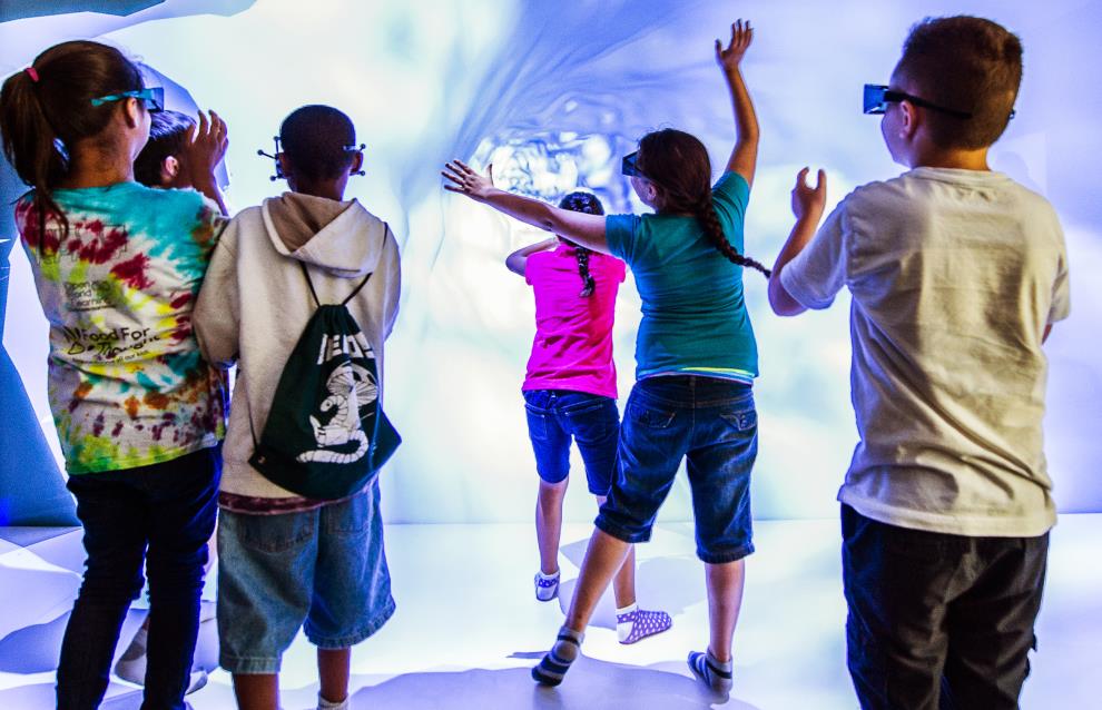 Photo of a group of children looking at a simulation projected on a wall.