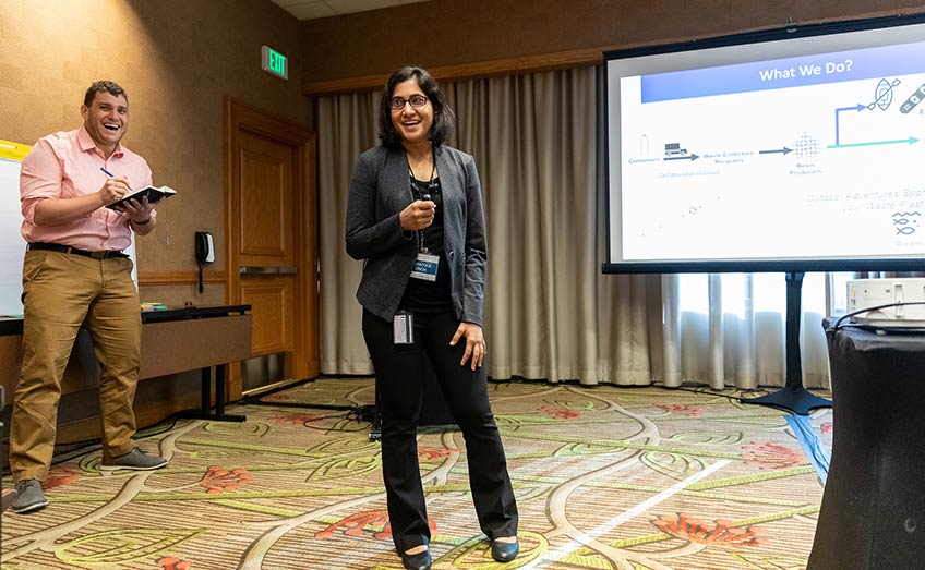 Two NREL researchers giving a presentation in a hotel conference room.
