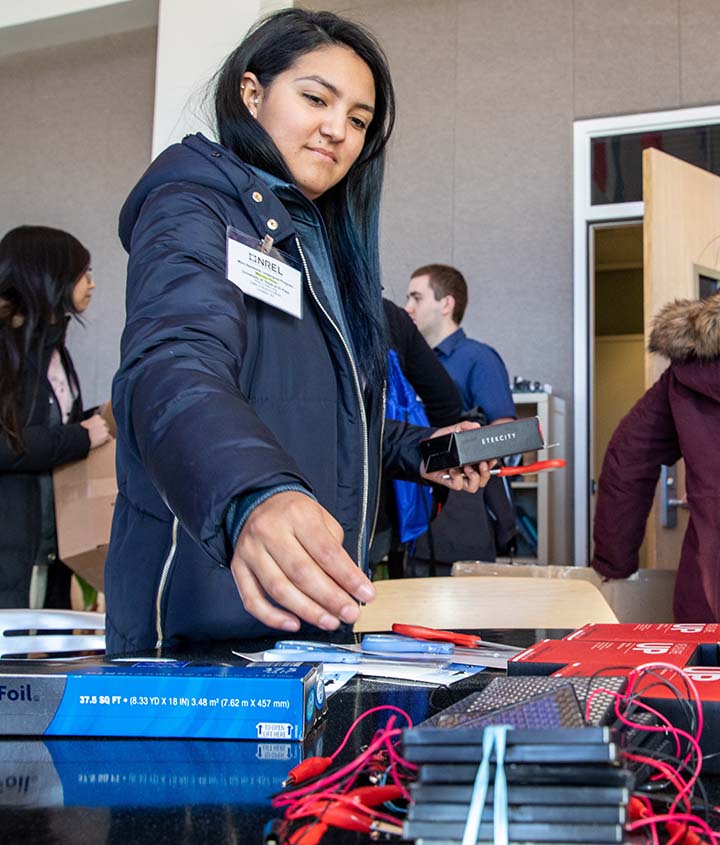 A woman holds electrical equipment.
