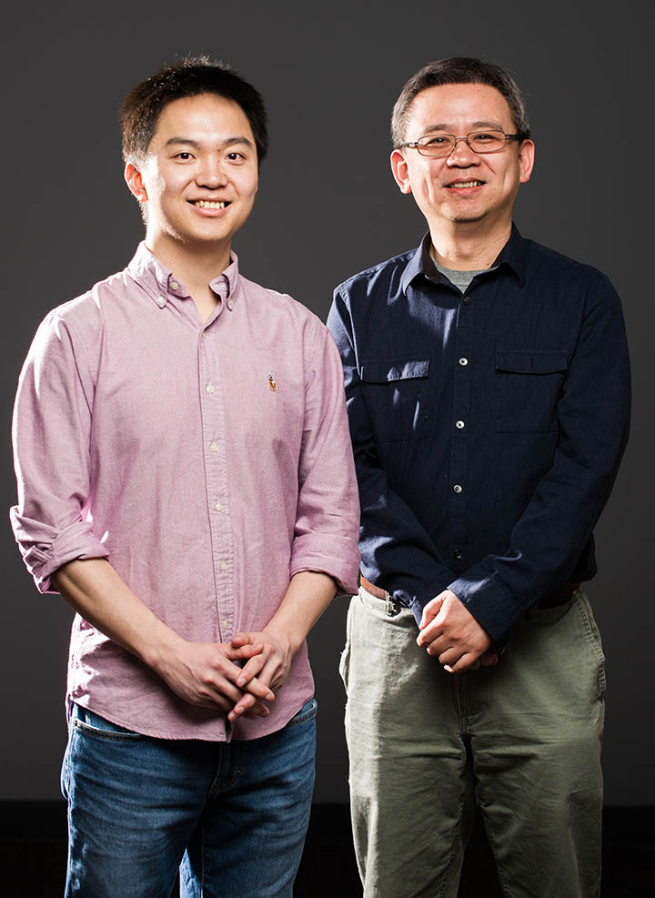 Two men stand to pose for a photo.