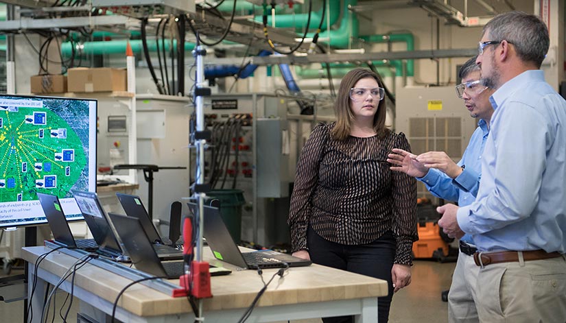 NREL researchers work on the advanced distribution management test bed in NREL's Energy Systems Integration Facility.