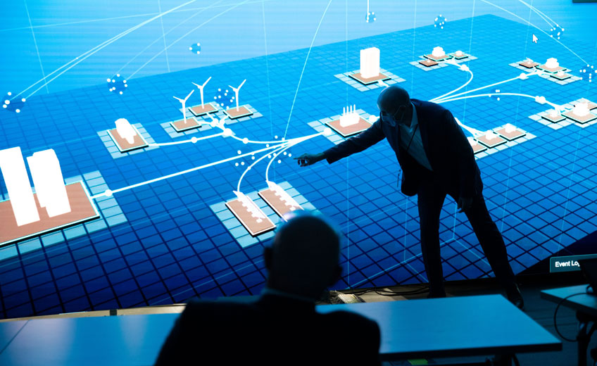 Photo of Cybersecurity Program Office Director Jonathan White demonstrating NREL’s cyber energy emulation platform on a large screen.