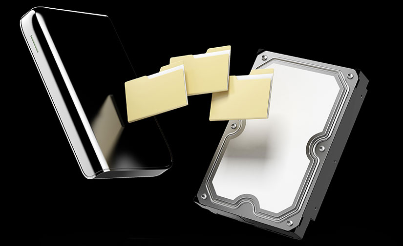 Graphic representation of folders of data moving from one hard disk drive to another.