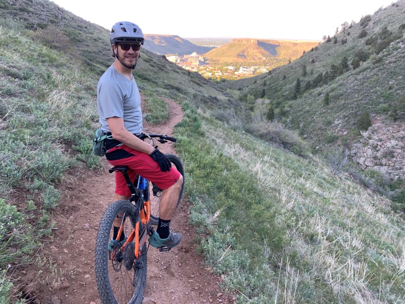 Kandler Smith stands with a bicycle on a trail.