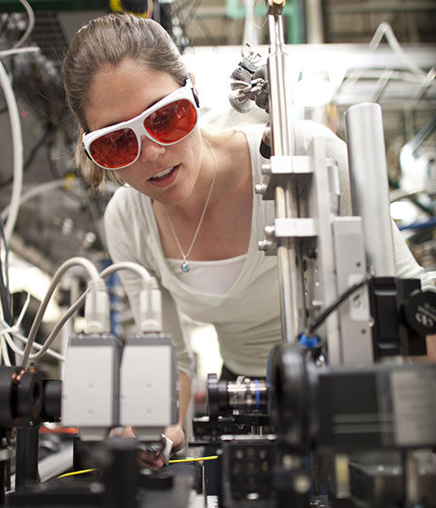 Photo of a woman wearing red-lens goggles in a lab