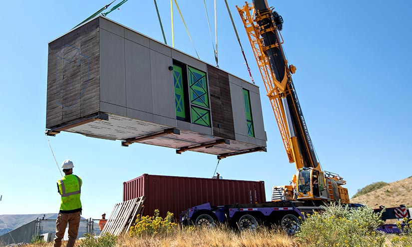 A prototype of a prefabricated housing unit–called a Blok–is lowered into place on NREL’s Golden, Colorado, campus as part of the IN2 program.