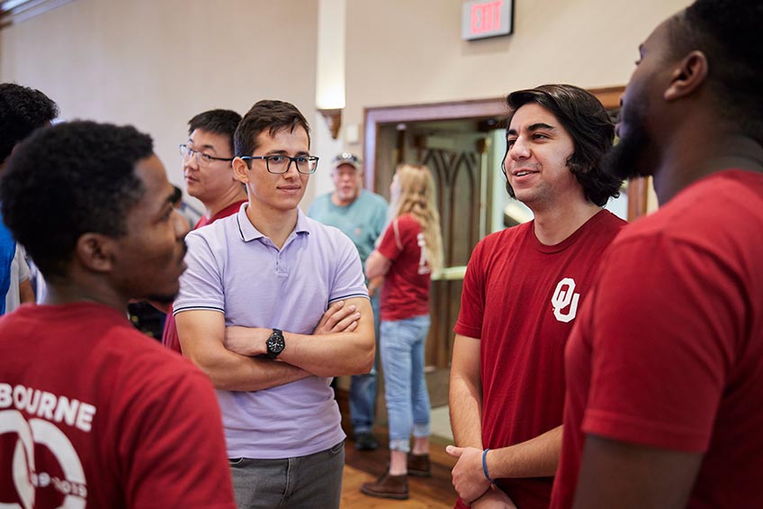 Students and community members chat in a ballroom.
