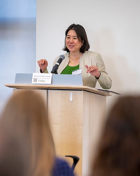 A woman speaks at a podium.