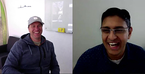 Two people smiling on a virtual call.