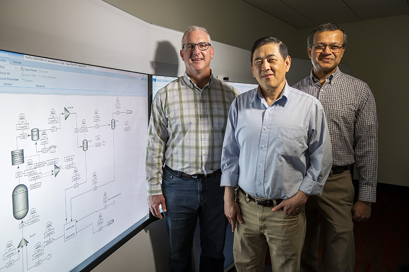 Three men standing near a display.