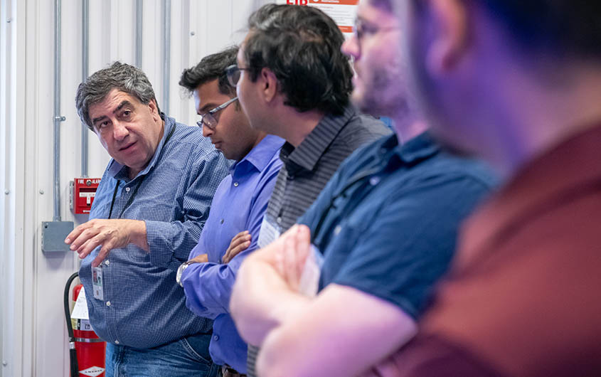 Rob Hovsapian gestures as he speaks to a group of four people